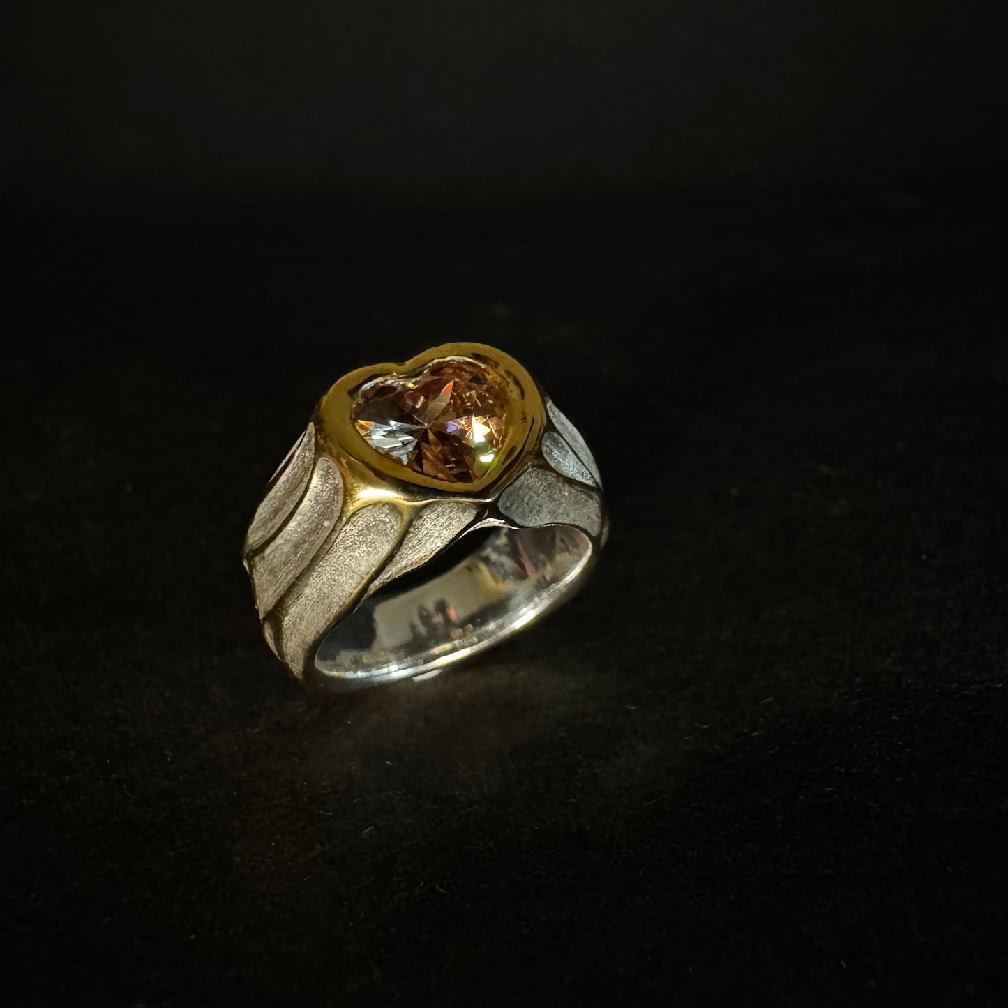 Two-tone ring with gold and silver design on a black background