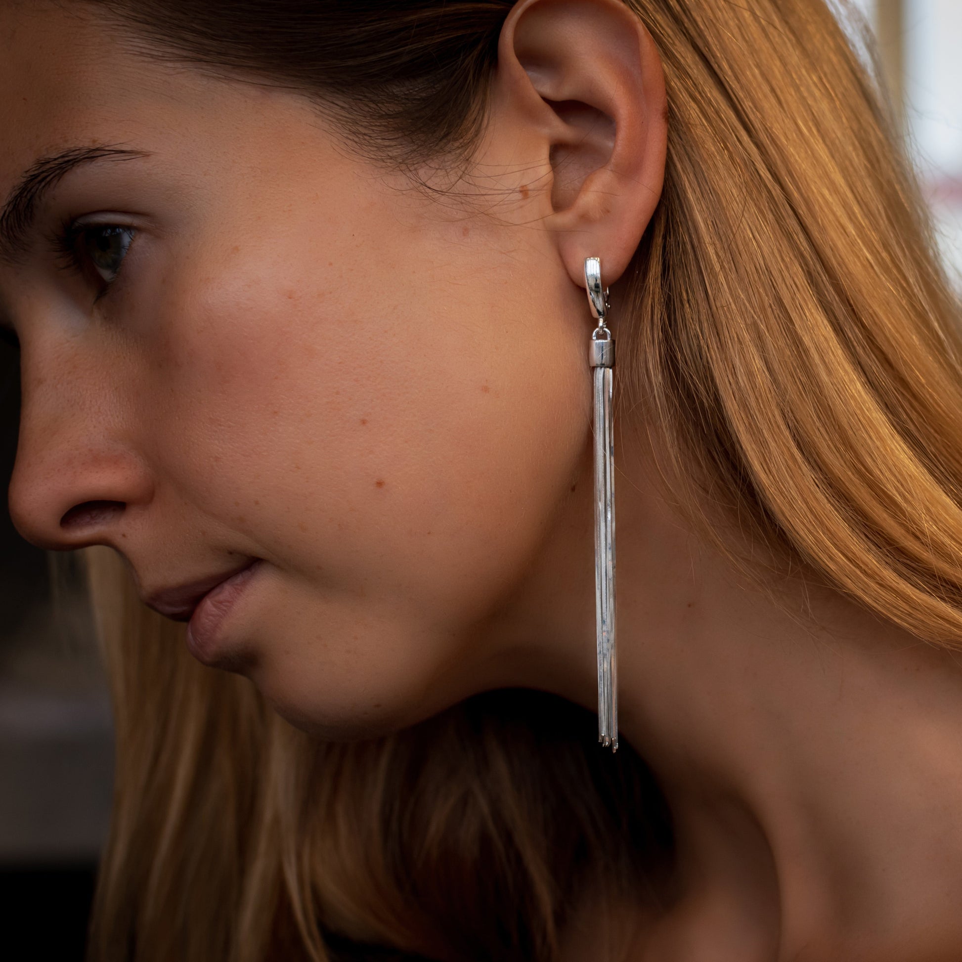 woman wearing dangle drop silver earrings